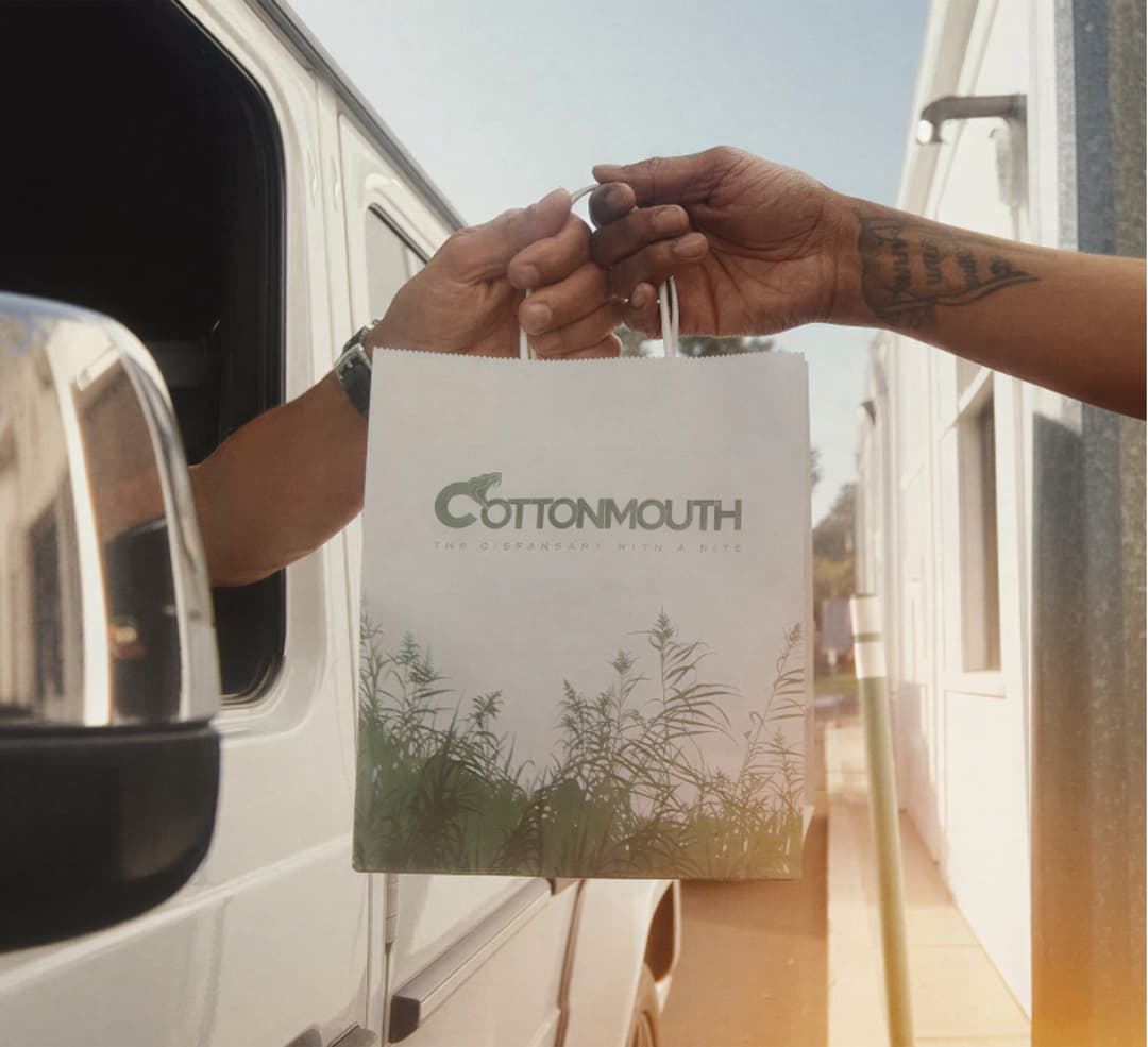 A branded Cottonmouth bag handed off at the express pickup window